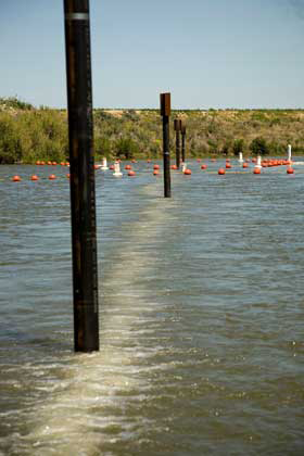 A surface image of a sound, bubble, and light barrier used to keep fish out of a target area. You can see bubbles breaking the surface along the line of the barrier. Image from http://deltacouncil.ca.gov/science-news/archives/2009-12-sound-air-and-light-barrier-keeps-chinook-out-of-old-river.phpc. 
